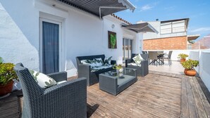 A rooftop patio with wicker furniture, a glass table, and potted plants. - Holiday Apartment "Cambrils Turistic Atico" with Private Terrace & Wi-Fi (Cambrils)