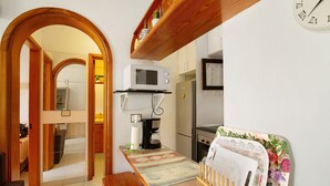 A compact kitchen with a microwave, coffee maker, and a refrigerator. - Vacation Apartment 'Residencial Sol Suite 2' with Sea View, Shared Pool and Wi-Fi (Puerto Rico)