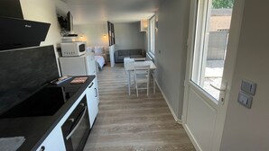 Een moderne keuken met een eethoek, een inbouwoven en een magnetron.