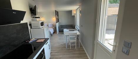 Et moderne køkken med spiseplads, indbygget ovn og mikroovn.
