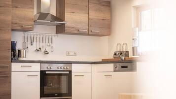 Una cucina moderna con mobili in legno, forno integrato e macchina da caffè.