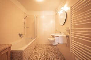 Ein Badezimmer mit Badewanne, Dusche, Toilette und Waschbecken.