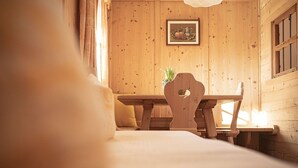 A wooden interior with a dining table and chairs, a framed picture on the wall, and a window with curtains. - Holiday Apartment "Himmelschlüssel" with Mountain View, 2 Private Terraces & Wi-Fi (Acereto)