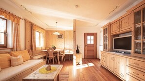A cozy wooden interior with a sofa, dining table, and cabinets. - Holiday Apartment "Himmelschlüssel" with Mountain View, 2 Private Terraces & Wi-Fi (Acereto)