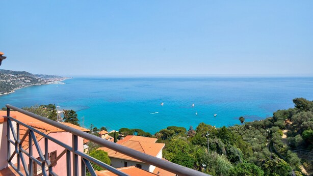 A coastal view with a clear sky, a balcony with a railing, and a pathway leading to a building. - Holiday Apartment "Casa Scotland" with Sea View, Private Terrace, and Wi-Fi (Ventimiglia)
