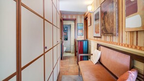 A narrow hallway with a wooden partition, a bench with a cushion, and a refrigerator. - Holiday Apartment "Casa Scotland" with Sea View, Private Terrace, and Wi-Fi (Ventimiglia)