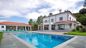A modern two-story house with a swimming pool, a covered patio with lounge chairs, and a well-maintained garden. - Holiday Home 'Quinta Grande' with Private Pool, Private Terrace and Wi-Fi (Chamusca)