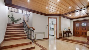 A wooden staircase with a handrail, a potted plant, and a view into a kitchen area. - Holiday Home 'Quinta Grande' with Private Pool, Private Terrace and Wi-Fi (Chamusca)