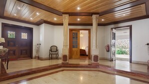 A spacious foyer with a wooden ceiling, large columns, a wooden door, and a view into a bedroom. - Holiday Home 'Quinta Grande' with Private Pool, Private Terrace and Wi-Fi (Chamusca)
