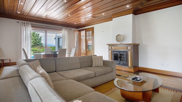 A modern living room with a sectional sofa, a glass coffee table, and a fireplace. - Holiday Home 'Quinta Grande' with Private Pool, Private Terrace and Wi-Fi (Chamusca)