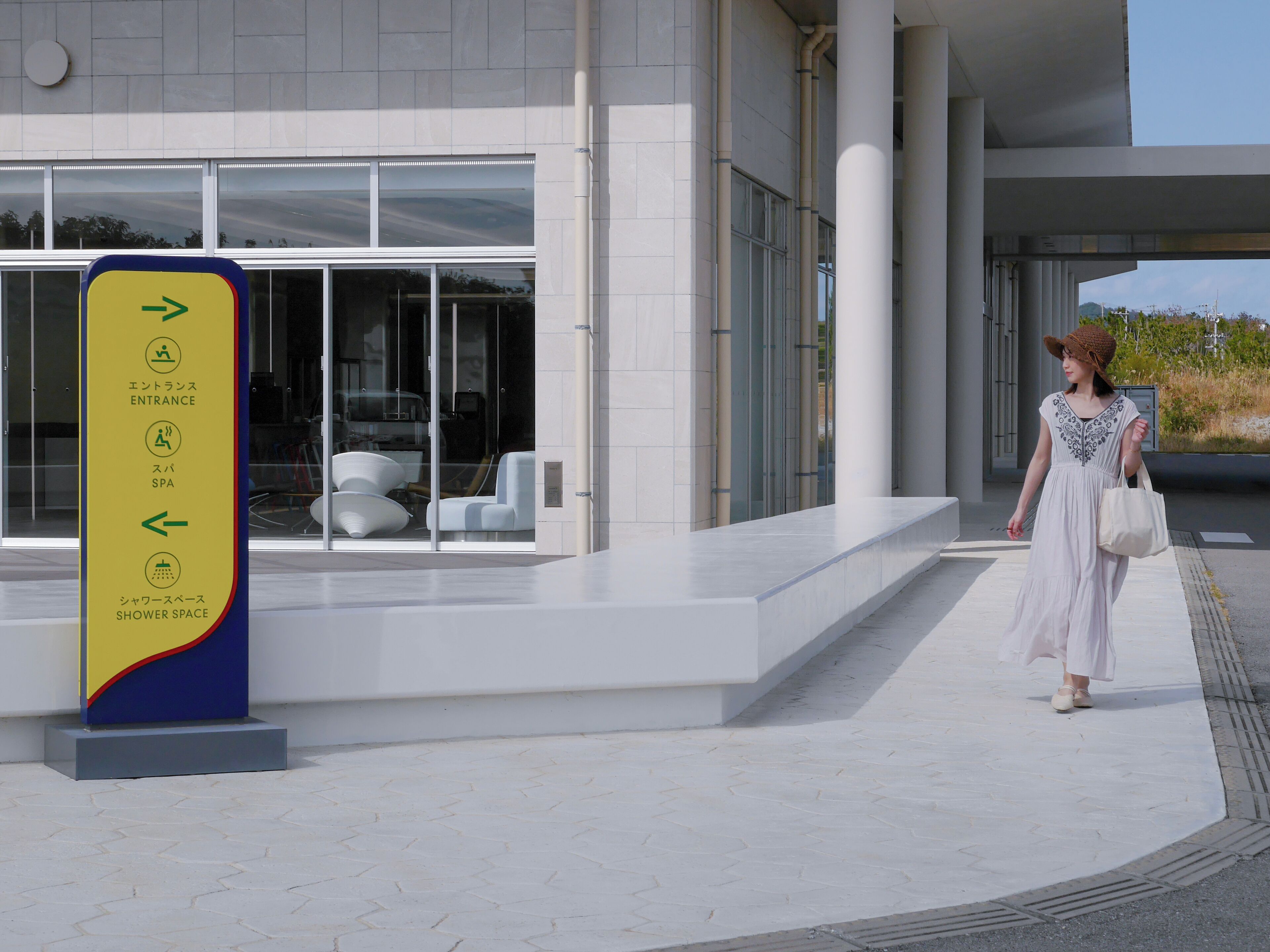 A modern building with a clear entrance sign indicating amenities like an entrance, spa, and shower space.