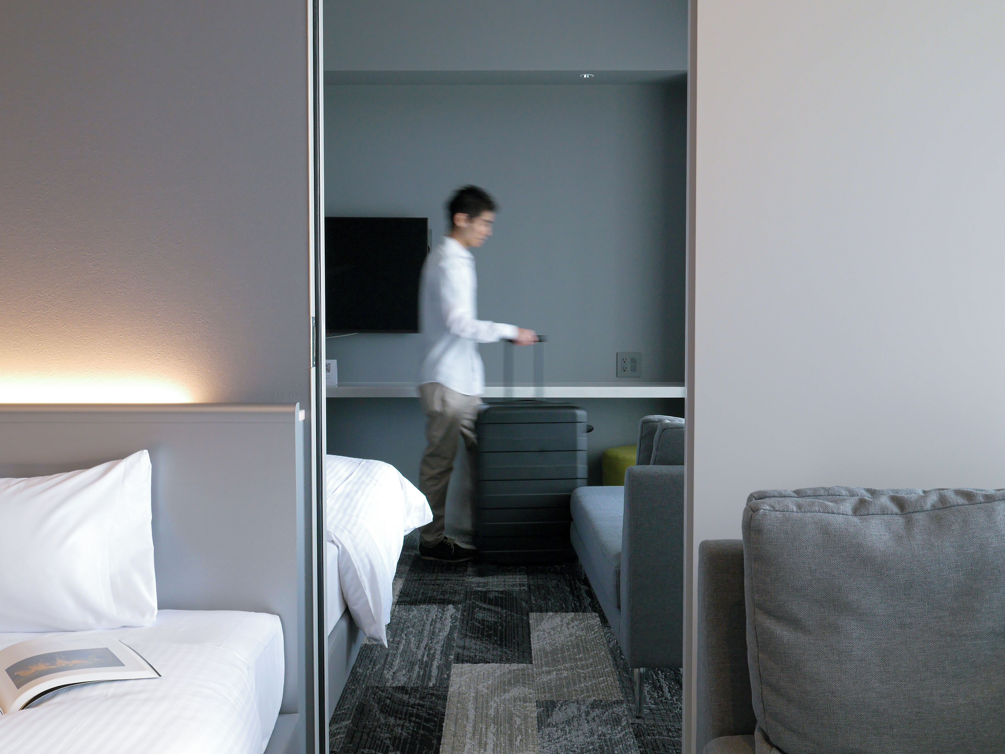 Habitación de hotel con cama, escritorio, silla y televisor.