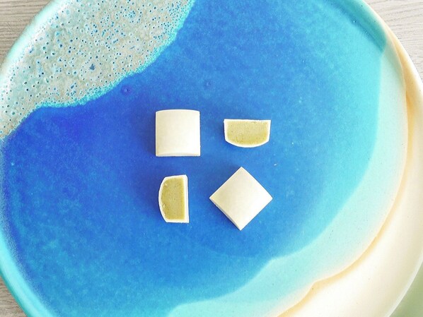 A blue ceramic plate with four white soap pieces on it.