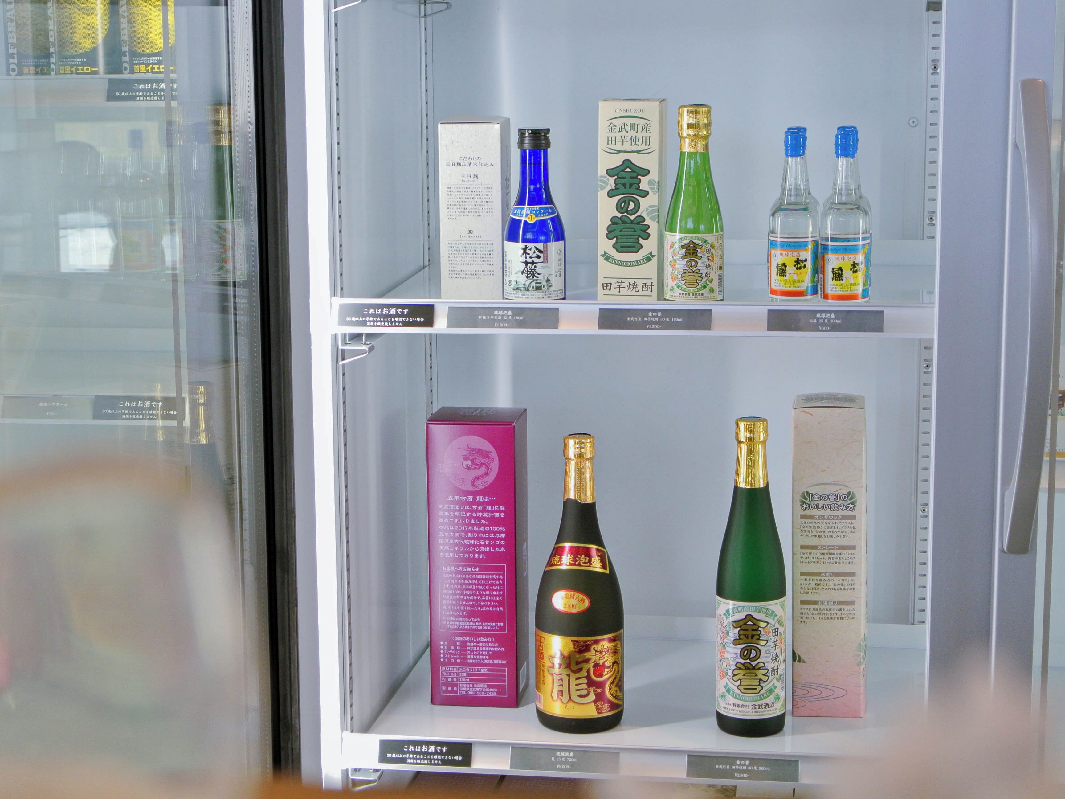 Una exhibición de diversas botellas y cajas, presumiblemente con bebidas, dispuestas en estantes.