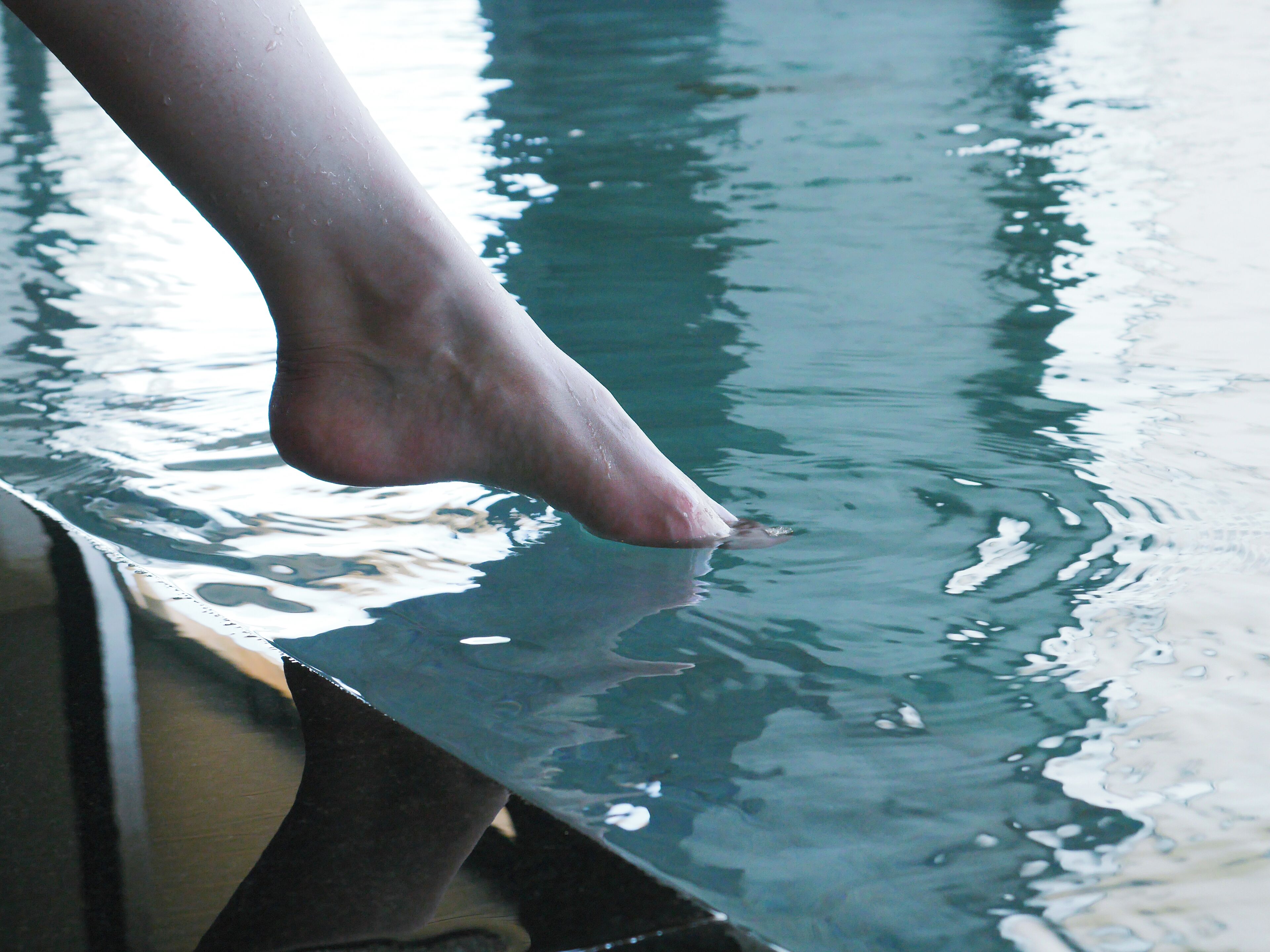 A person's foot hanging over the edge of a boat.