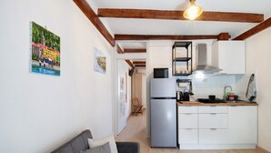A compact living space with a kitchenette, a sofa, and a dining area. - Holiday Apartment "Taronico Heron" with Lake View, Shared Terrace & Wi-Fi (bellagio)