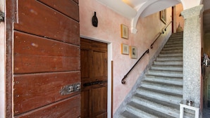 A wooden door, a staircase with stone steps, and a wall with framed pictures. - Holiday Apartment "Taronico Heron" with Lake View, Shared Terrace & Wi-Fi (bellagio)