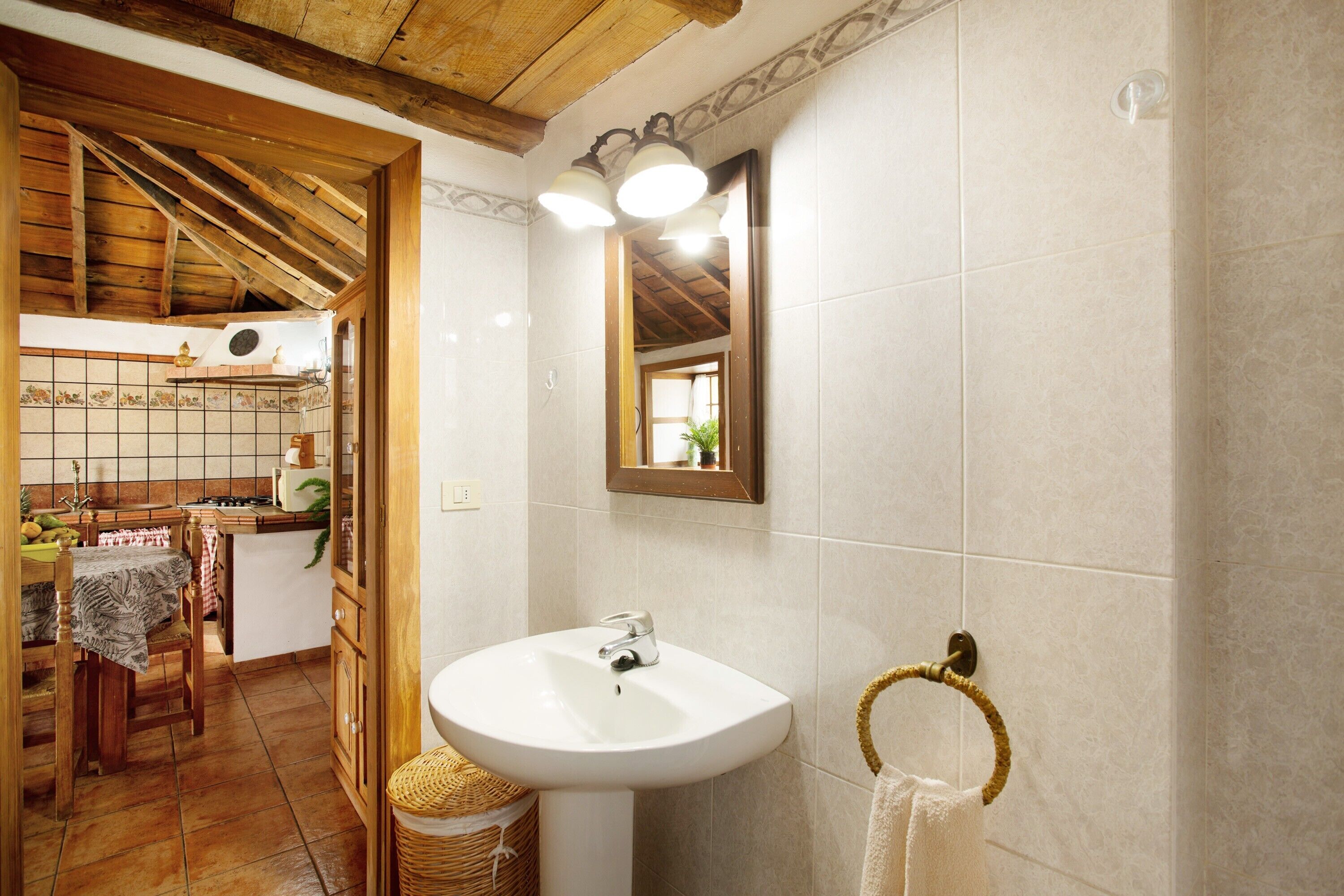 Une salle de bain équipée d’un lavabo, d’un miroir et d’un porte-serviettes.