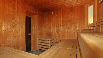 Un sauna en bois, doté de bancs et d’une banquette.