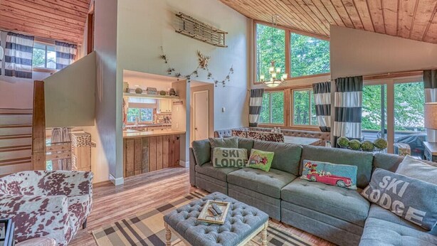 A cozy lodge interior with a sofa set, a dining area, and a kitchen.