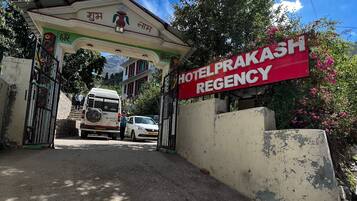 L'entrada de l'Hotel Prakash Regency, amb una placa, una porta i un camí que condueix al edifici.
