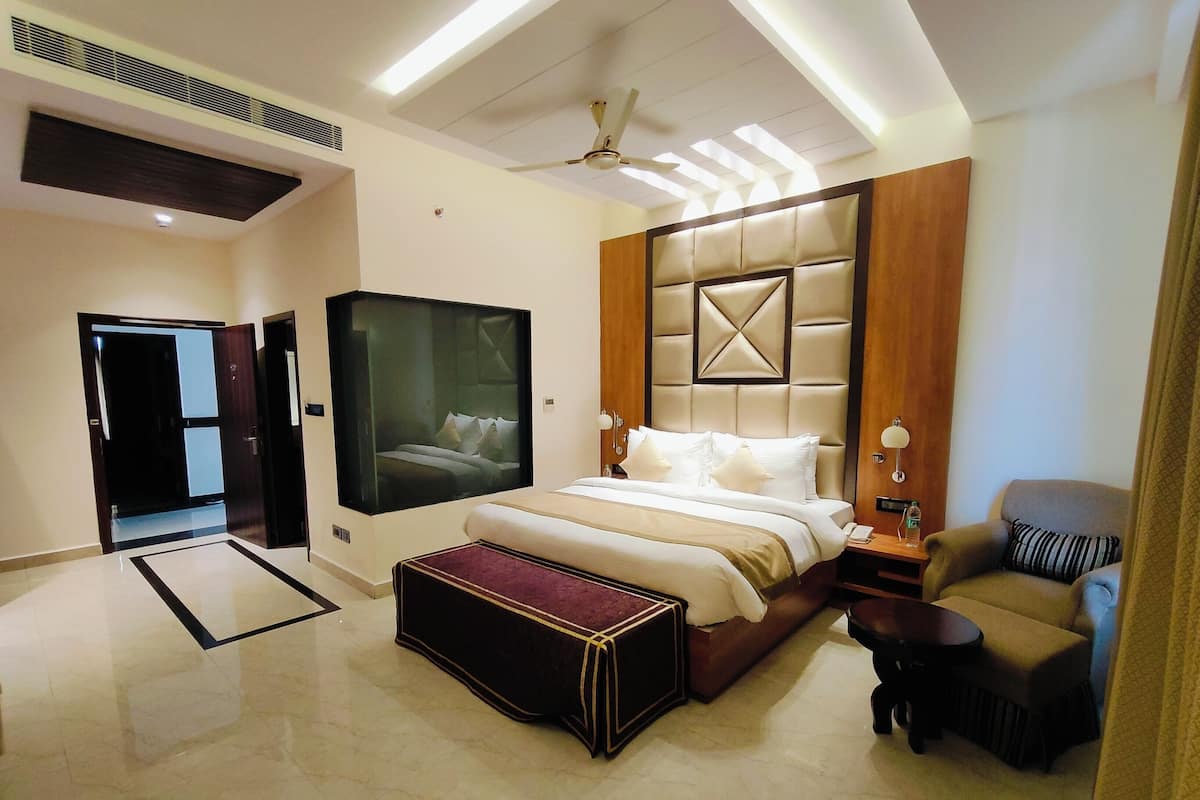 Una habitación de hotel moderna con una cama grande, un área de descanso y un televisor.