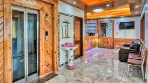 Un interior de madera con un mostrador de recepción, un lavamanos, un espejo y una zona de estar.