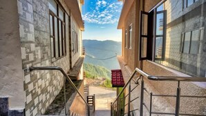 Una escalera estrecha que lleva a un balcón con vistas a un lago y montañas.