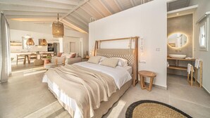 Un dormitorio amplio con una cama grande, una mesita de noche y un tocador empotrado con espejo.