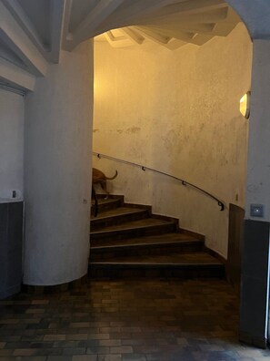 A staircase with a handrail leading to a landing, surrounded by walls with a textured finish. - GuestReady - Glimpse of dawn in Asnières-sur-Seine (Asnières-sur-Seine)