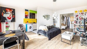 A modern living room with a sofa, coffee table, and a bookshelf. - GuestReady - Glimpse of dawn in Asnières-sur-Seine (Asnières-sur-Seine)