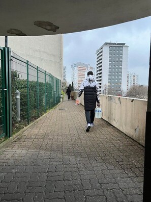 A pedestrian walkway with a metal fence on one side and a concrete wall on the other. - GuestReady - Glimpse of dawn in Asnières-sur-Seine (Asnières-sur-Seine)