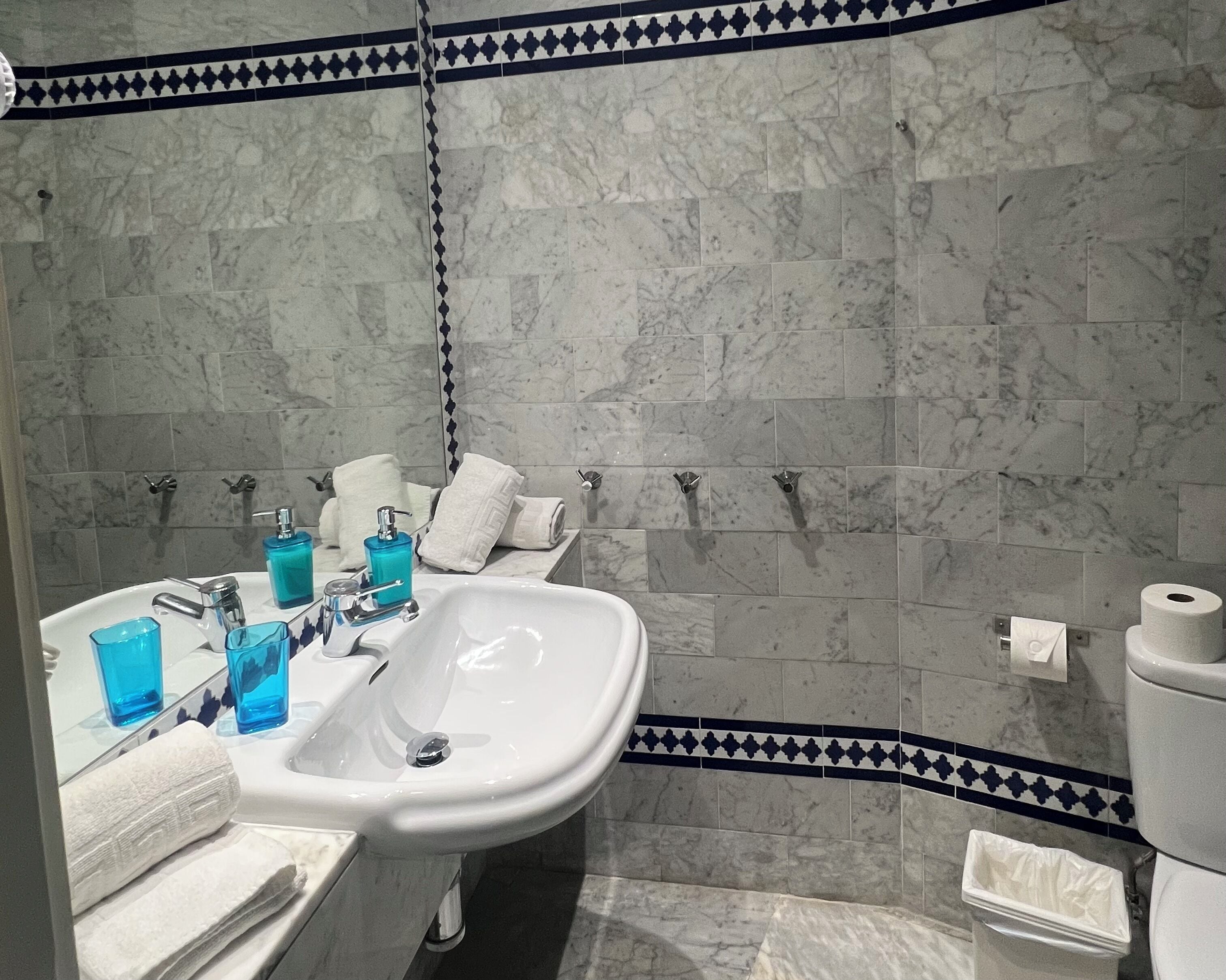 Une salle de bain équipée d’un lavabo, d’un miroir et d’un porte-serviettes.