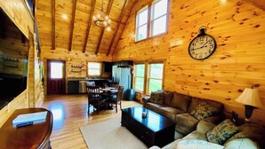 L’intérieur d’une cabane en rondins comprend un coin repas, un salon et une cuisine.
