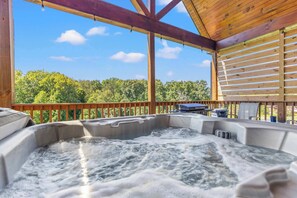 A hot tub with a wooden deck and a view of trees. - Daze Off - Natural Bridge, Luxury, Hot Tub, SUP Ky (Rogers)