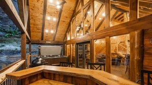 A rustic wooden interior with a stone wall, a wooden bench, and a fireplace. - Cabin of Freedom Falls -Private Waterfall, Hot Tub- Secluded & Luxury Log Cabin Retreat (Slade)