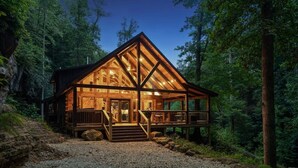 A cabin with a wooden exterior, a porch, and a staircase leading to the entrance. - Cabin of Freedom Falls -Private Waterfall, Hot Tub- Secluded & Luxury Log Cabin Retreat (Slade)