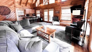 A log cabin interior with a living room, dining area, and kitchen. - Horseshoe Falls-RRG-Hot tub! (Rogers)