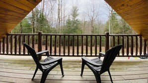 A wooden deck with two chairs, a railing, and a view of trees. - Mountain Chalet |Hot Tub | Centrally Located | RRG (Campton)