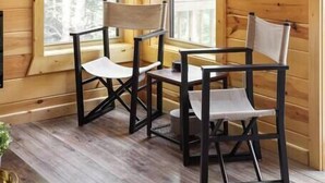 A wooden cabin interior with two windows, a table, and two chairs. - Scenic Sunset Cabin RRG | Central | Hot Tub | Pets (Campton)