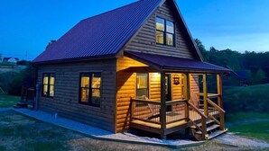 A log cabin with a porch and a small staircase leading up to the entrance.