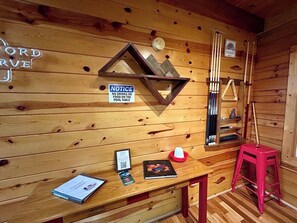 A wooden cabin interior with a pool table, a notice sign, a framed picture, and a red stool. - Terrapin Station - Valley View, Hot Tub, Game Room (Rogers)
