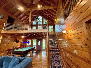 A wooden cabin with a pool table, a balcony, and a staircase leading to an upper level. - Terrapin Station - Valley View, Hot Tub, Game Room (Rogers)