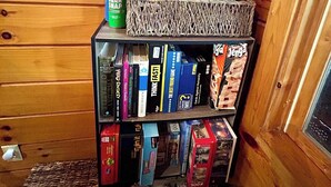 Ein Holzregal mit verschiedenen Gesellschaftsspielen und Büchern.