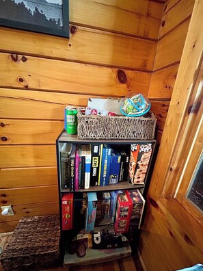 Una libreria in legno con diversi giochi da tavolo e libri.