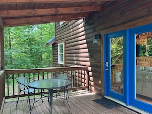 Enjoy outdoor dining or relaxation on the covered porch with a round table and four chairs.