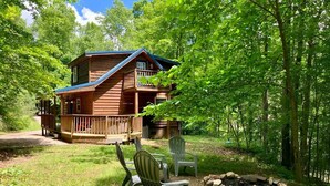 A cabin with a deck, surrounded by trees and a fire pit. - Wildcat Cabin • Pet Friendly, Hot Tub, Forest Stay (Stanton)
