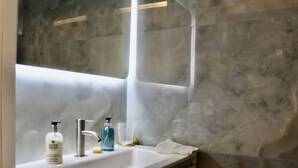 A bathroom with a white sink, a mirror, and a towel rack.