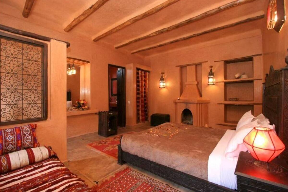 A cozy room with a bed, a fireplace, and a bookshelf.