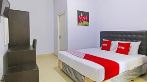 A hotel room with a bed, a staircase, a door, and a wall-mounted air conditioner. - Hotel O Homestay Al Maidah (Depok)